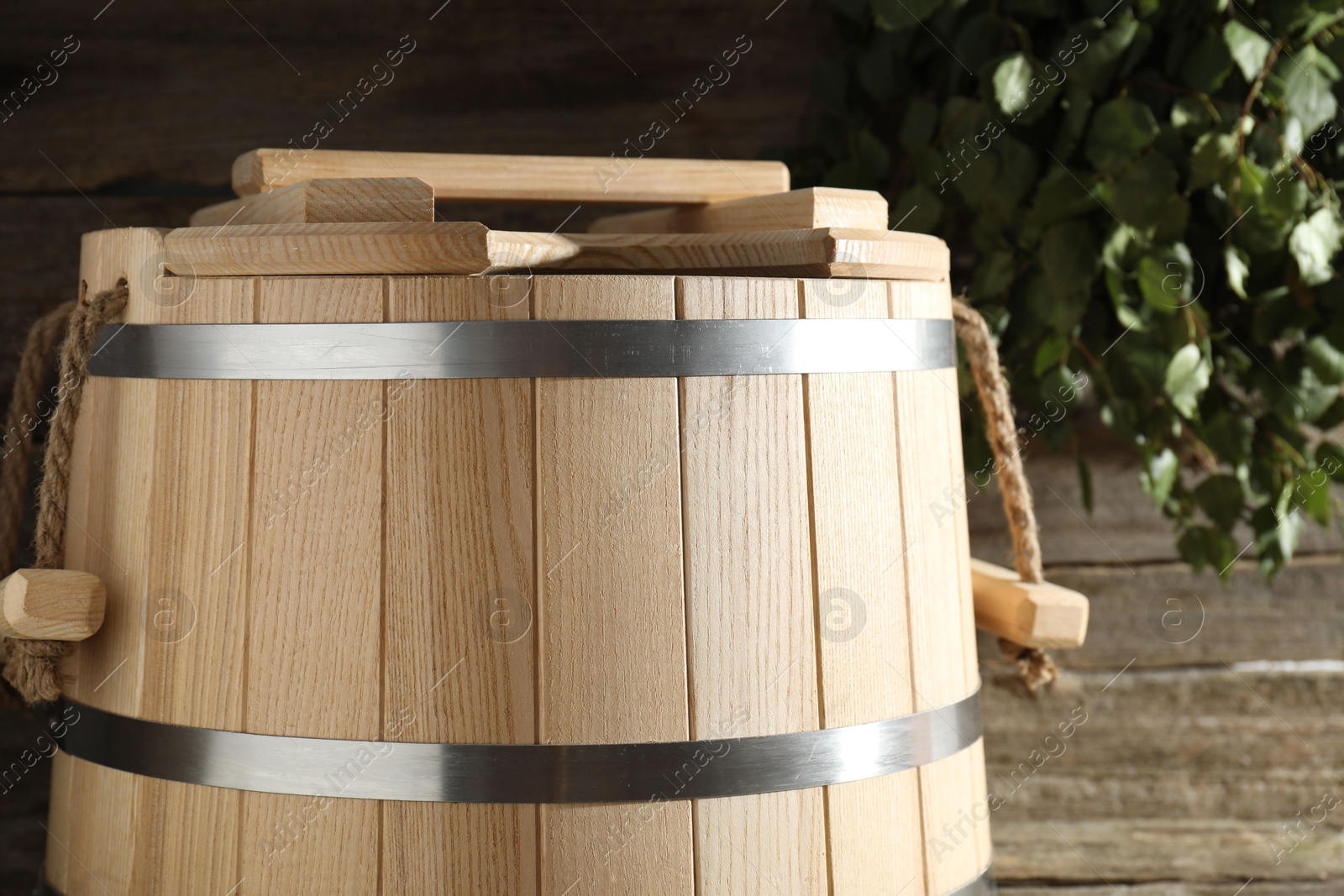 Photo of Sauna equipment. Bucket on wooden surface, closeup