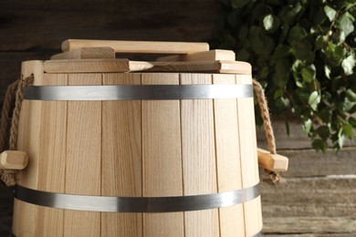 Photo of Sauna equipment. Bucket on wooden surface, closeup