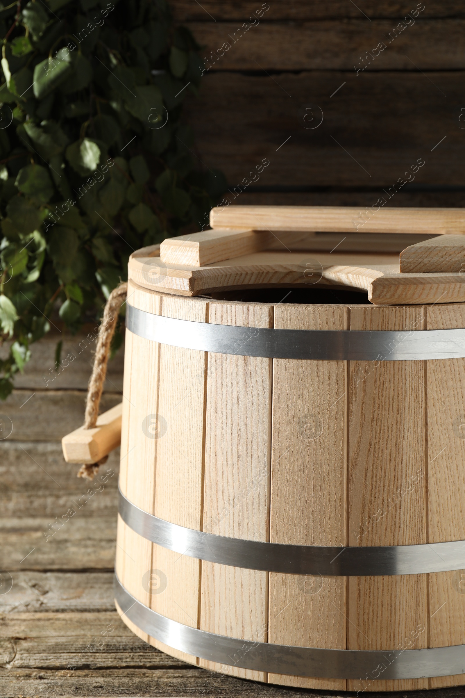 Photo of Sauna equipment. Bucket on wooden surface, closeup