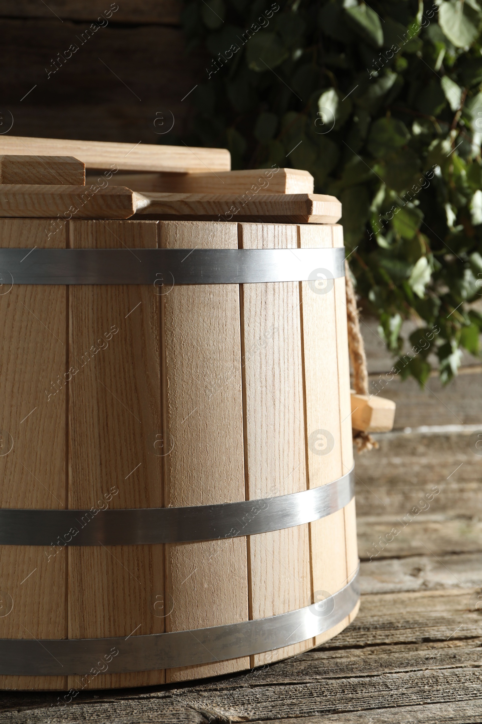 Photo of Sauna equipment. Bucket on wooden surface, closeup