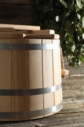 Sauna equipment. Bucket on wooden surface, closeup