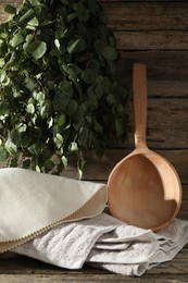 Photo of Sauna equipment. Felt wool hat, ladle and towel on wooden surface