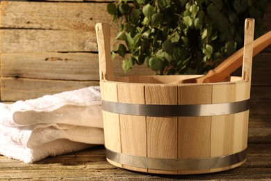 Sauna equipment. Bucket, ladle and towel on wooden surface