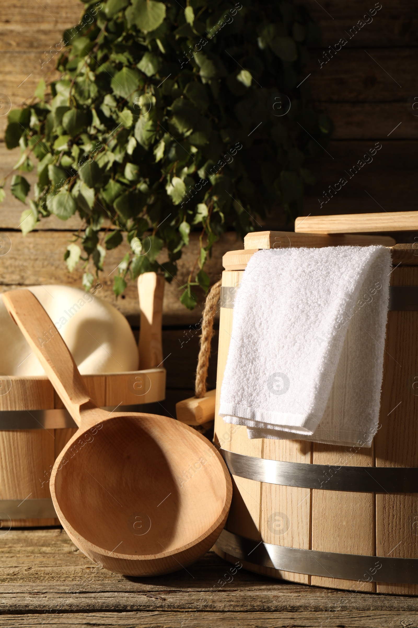 Photo of Sauna equipment. Buckets, ladle and towel on wooden surface