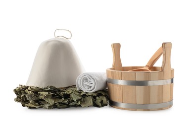 Photo of Sauna equipment. Wooden bucket with ladle, felt wool hat, oak whisk and towel isolated on white