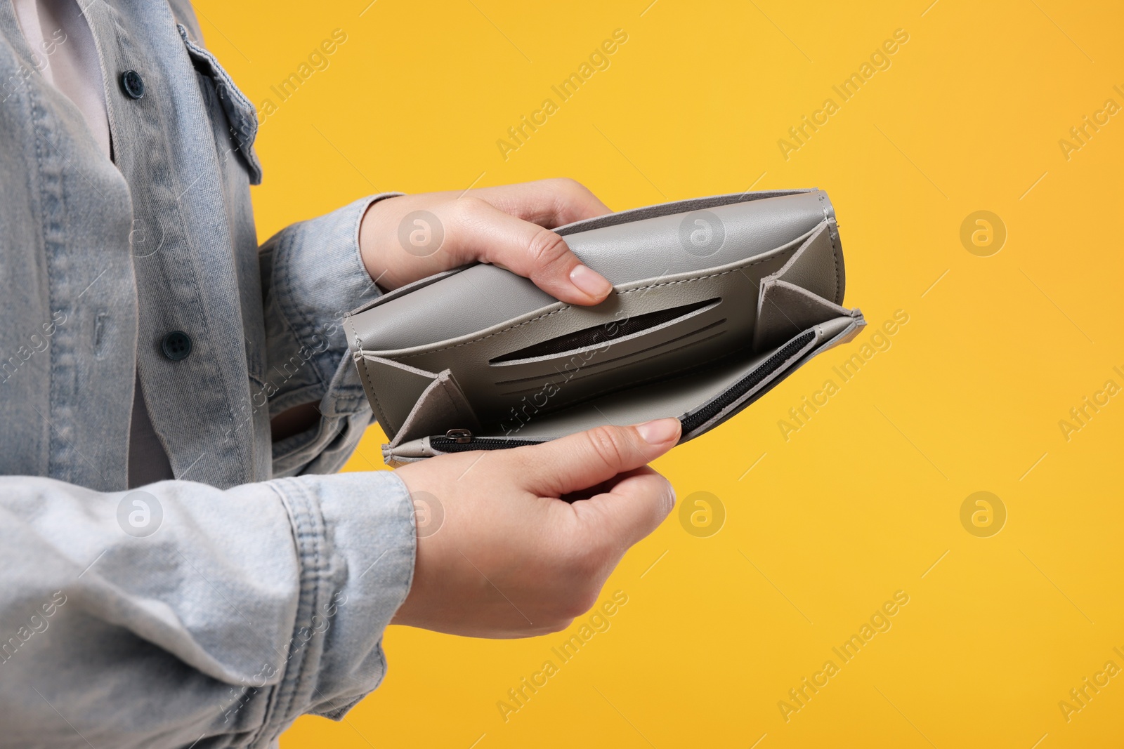 Photo of Woman with empty wallet on orange background, closeup