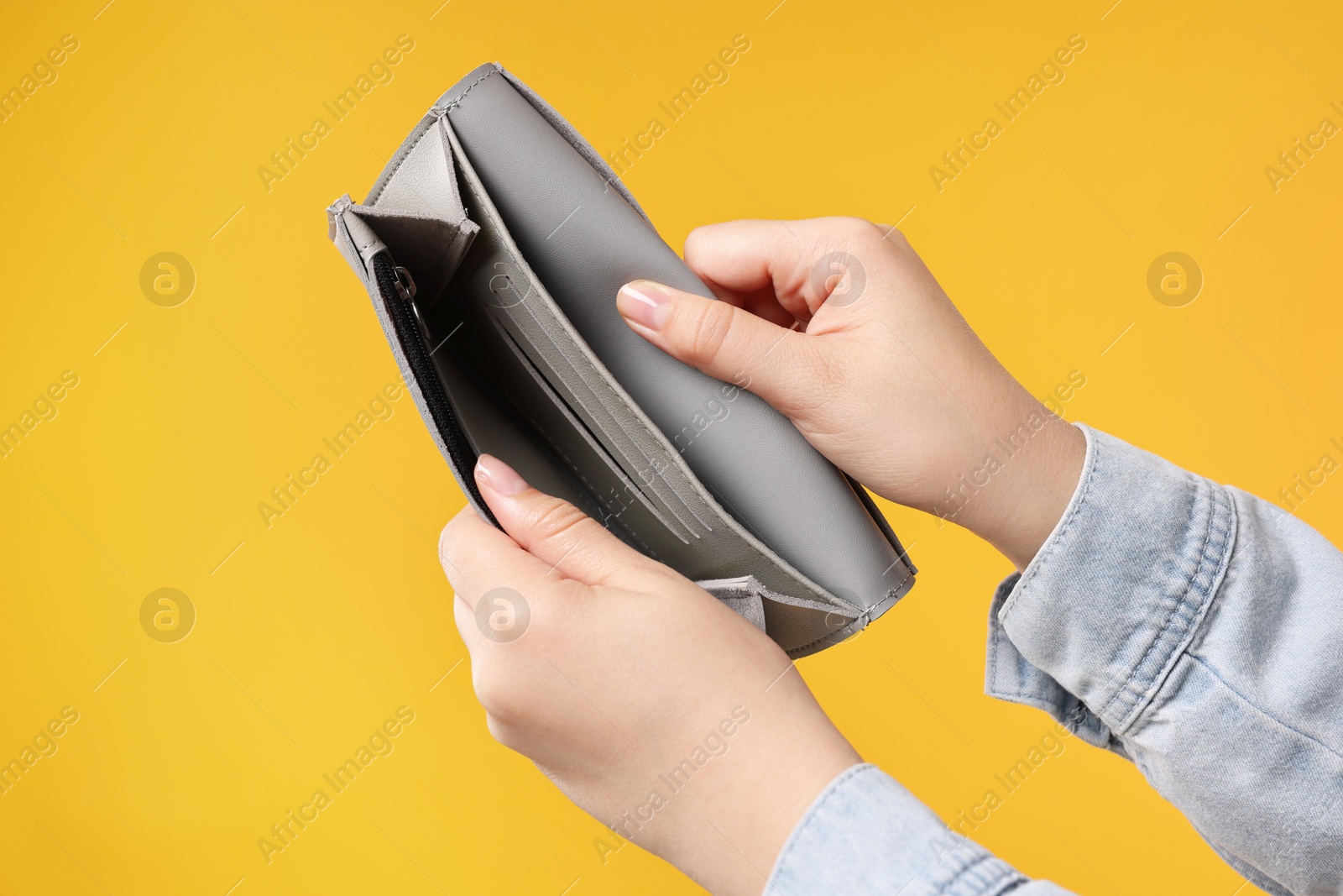 Photo of Woman with empty wallet on orange background, closeup