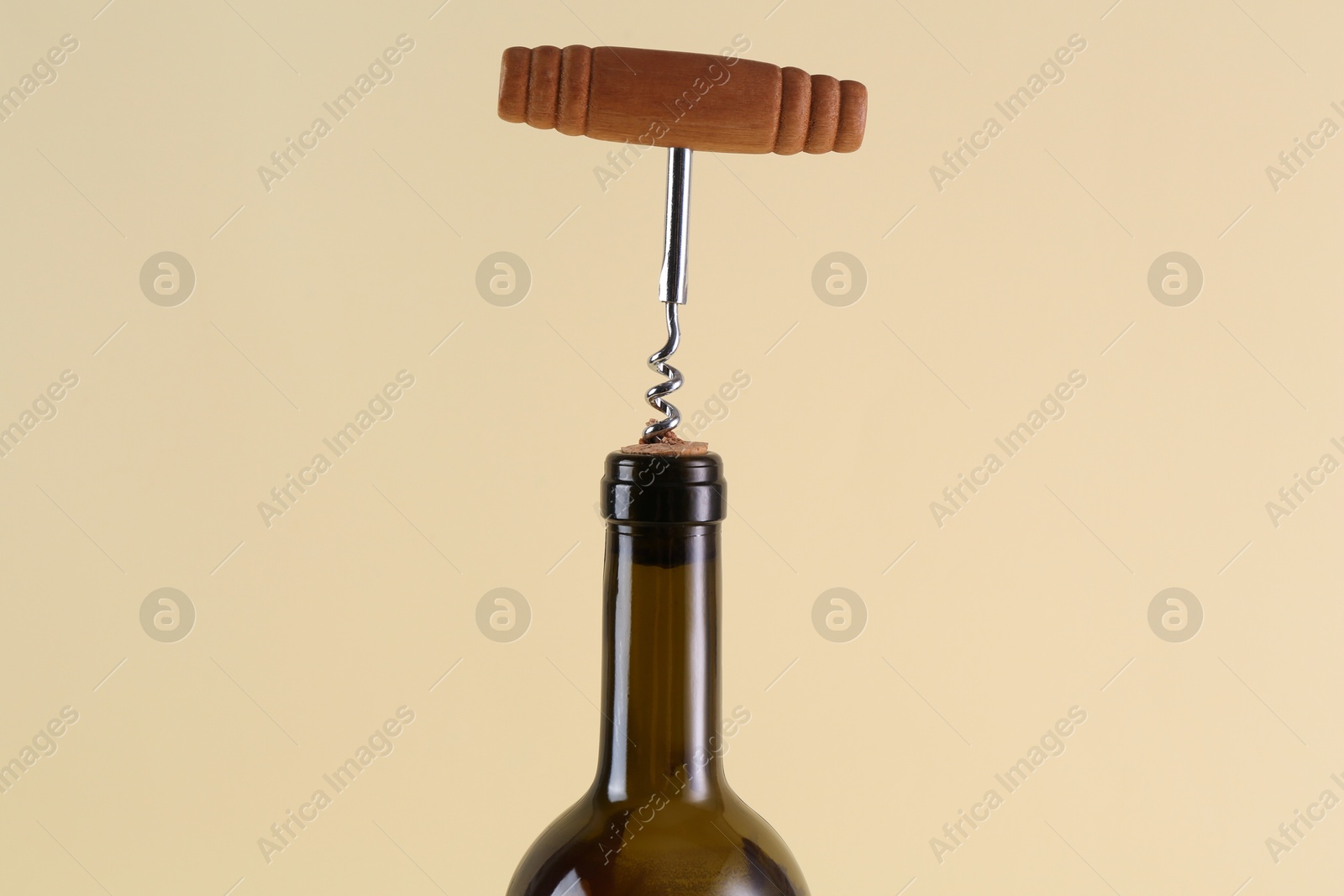 Photo of Wine bottle with corkscrew on beige background