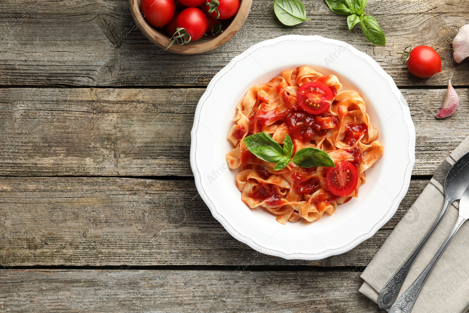 Photo of Delicious pasta with tomato sauce served on wooden table, flat lay. Space for text