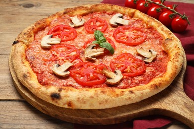 Photo of Delicious pizza with tomatoes, mushrooms and basil on wooden table, closeup