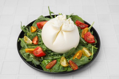 Photo of Delicious burrata salad on white tiled table, closeup