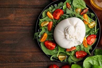 Delicious burrata salad and products on wooden table, flat lay. Space for text