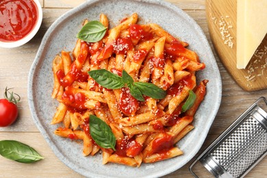 Photo of Delicious pasta with tomato sauce, basil and cheese on wooden table, flat lay