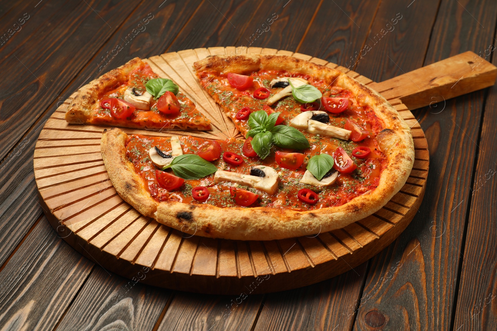 Photo of Tasty pizza with basil, mushrooms, chili pepper and tomato on wooden table, closeup