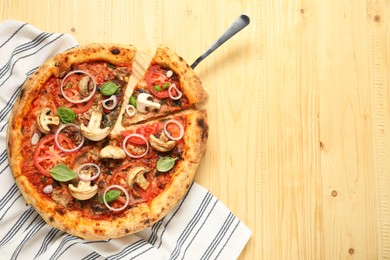 Tasty pizza with basil, mushrooms, onion and tomato on wooden table, top view. Space for text