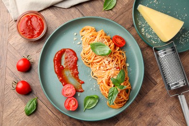 Photo of Delicious pasta with tomato sauce, basil and cheese on wooden table, flat lay