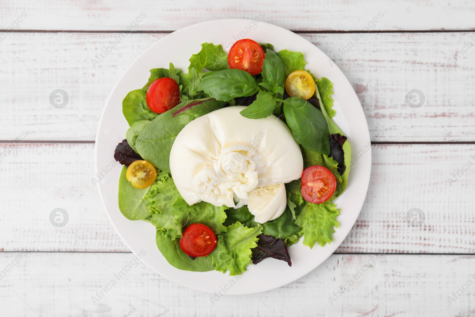 Photo of Delicious fresh burrata salad on white wooden table, top view