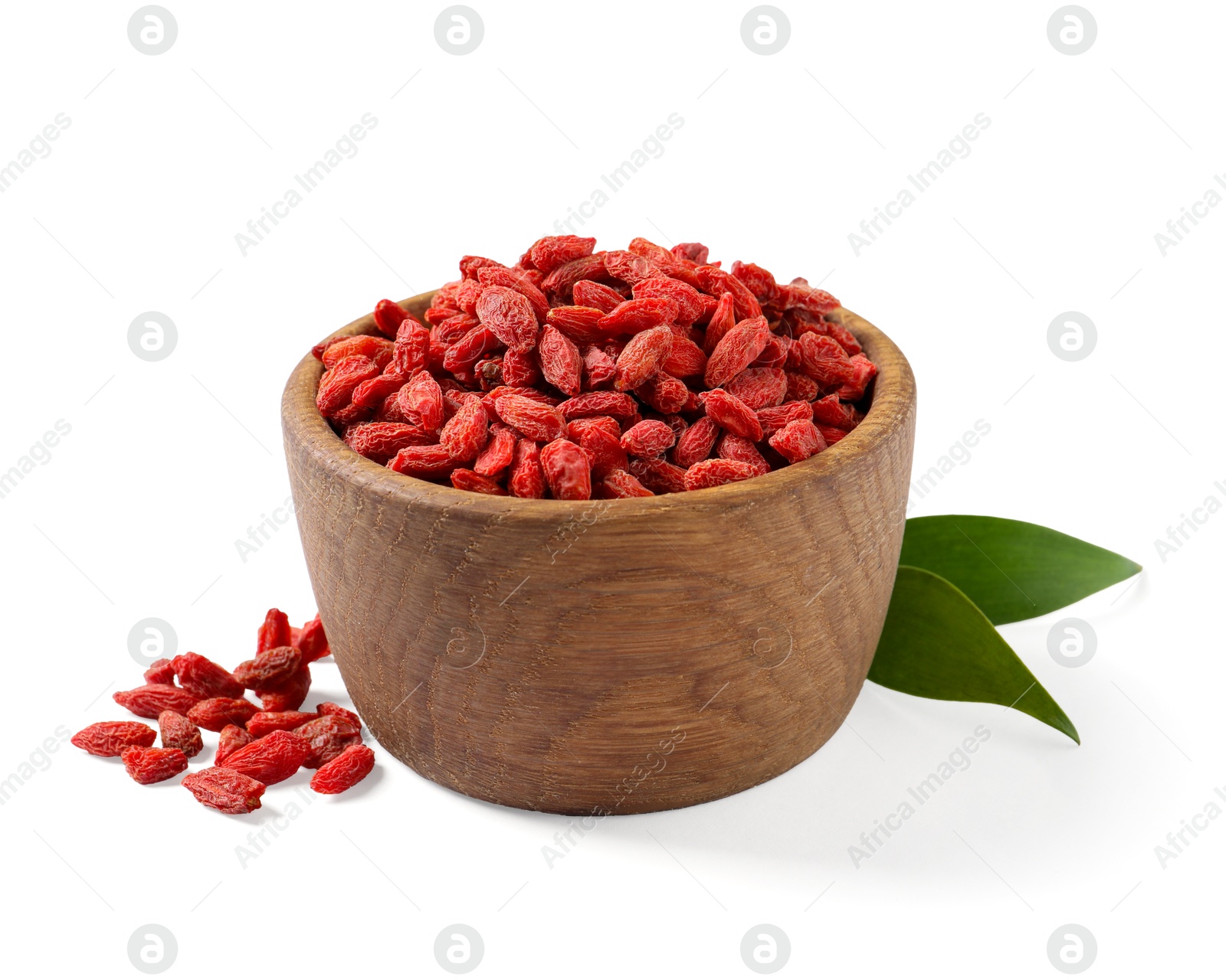 Photo of Dried goji berries in bowl and green leaves isolated on white