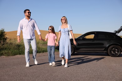 Photo of Parents, their daughter and car outdoors. Family traveling