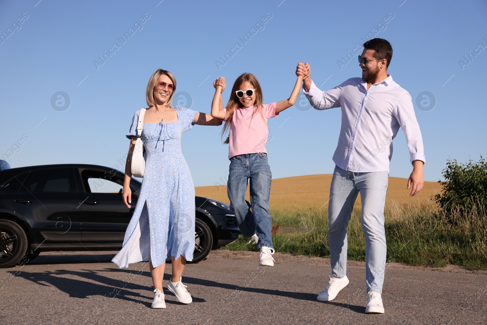 Photo of Parents, their daughter and car outdoors. Family traveling