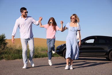 Parents, their daughter and car outdoors. Family traveling