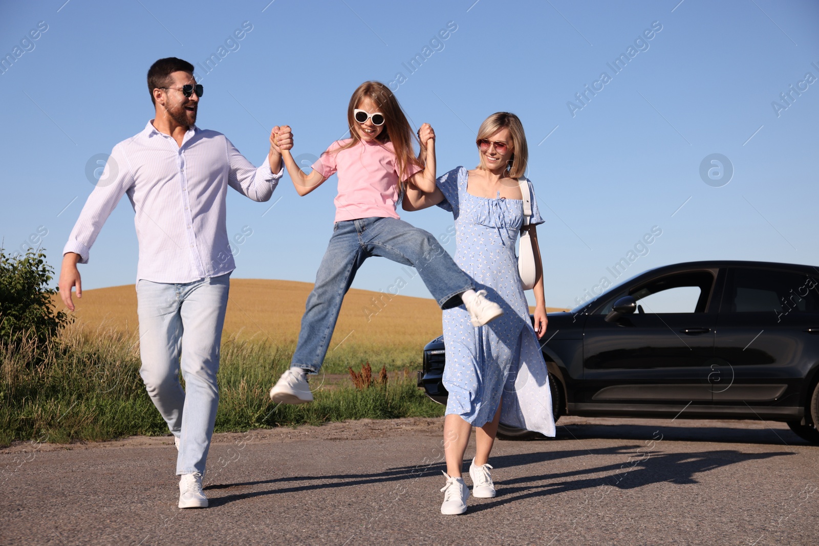 Photo of Parents, their daughter and car outdoors. Family traveling