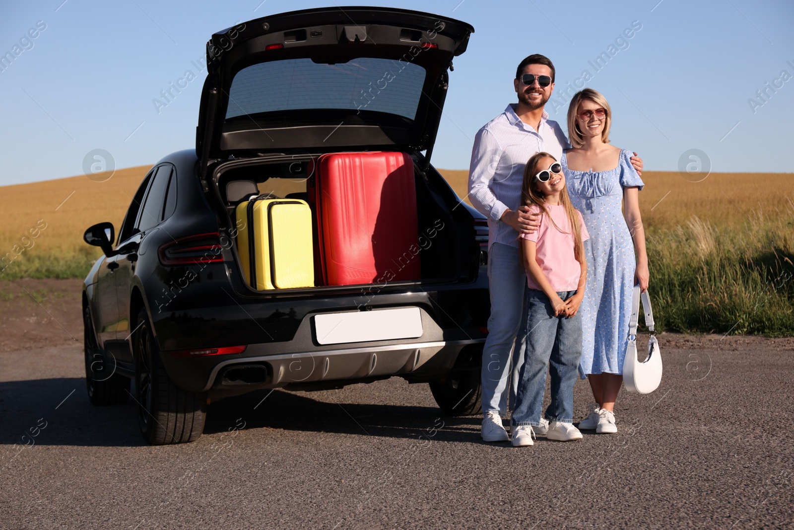 Photo of Happy family near car with suitcases outdoors