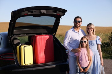 Photo of Happy family near car with suitcases outdoors