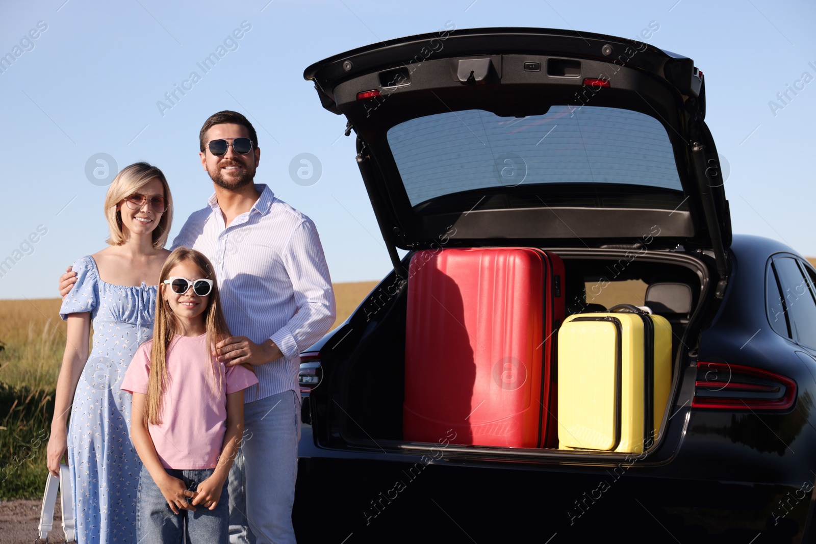 Photo of Happy family near car with suitcases outdoors