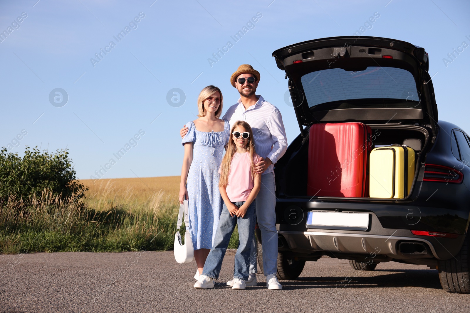 Photo of Happy family near car with suitcases outdoors, space for text