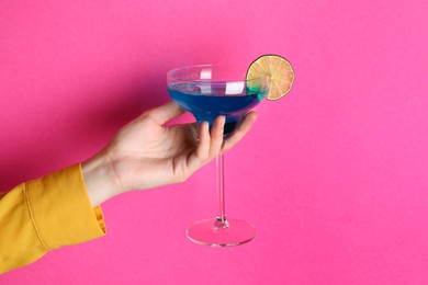 Photo of Woman with glass of refreshing cocktail on pink background, closeup