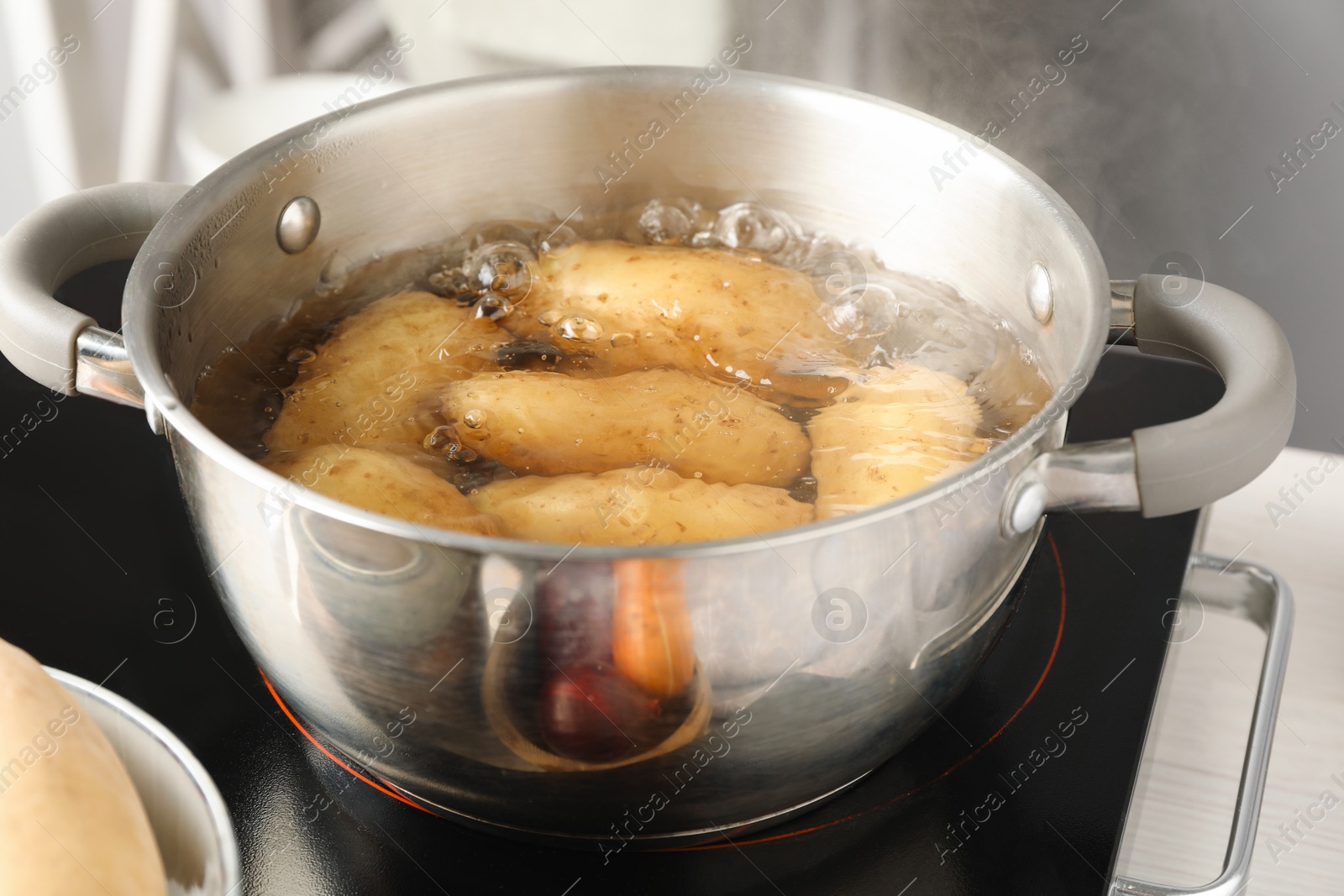 Photo of Boiling potatoes in metal pot on stove