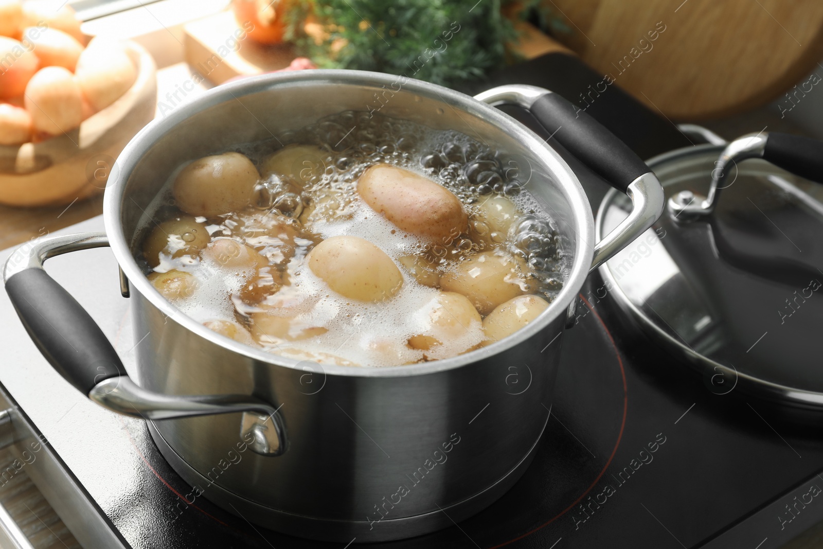 Photo of Boiling potatoes in pot on stove in kitchen