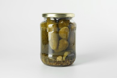 Pickled cucumbers in jar on light background