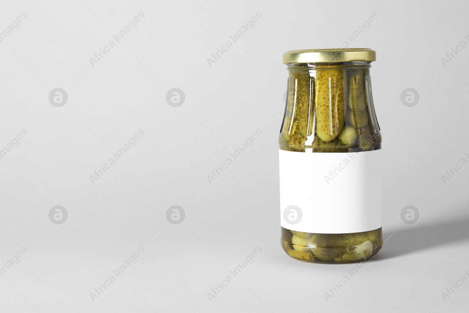 Photo of Pickled cucumbers in jar on light background. Space for text