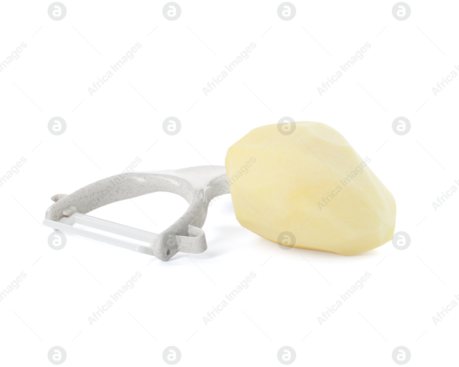 Photo of Fresh raw potato and peeler isolated on white