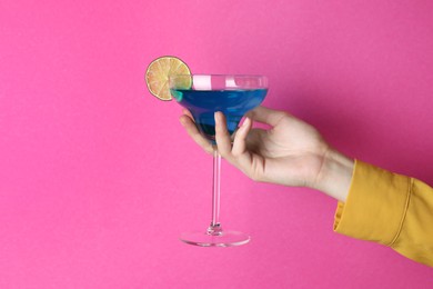 Photo of Woman with glass of refreshing cocktail on pink background, closeup