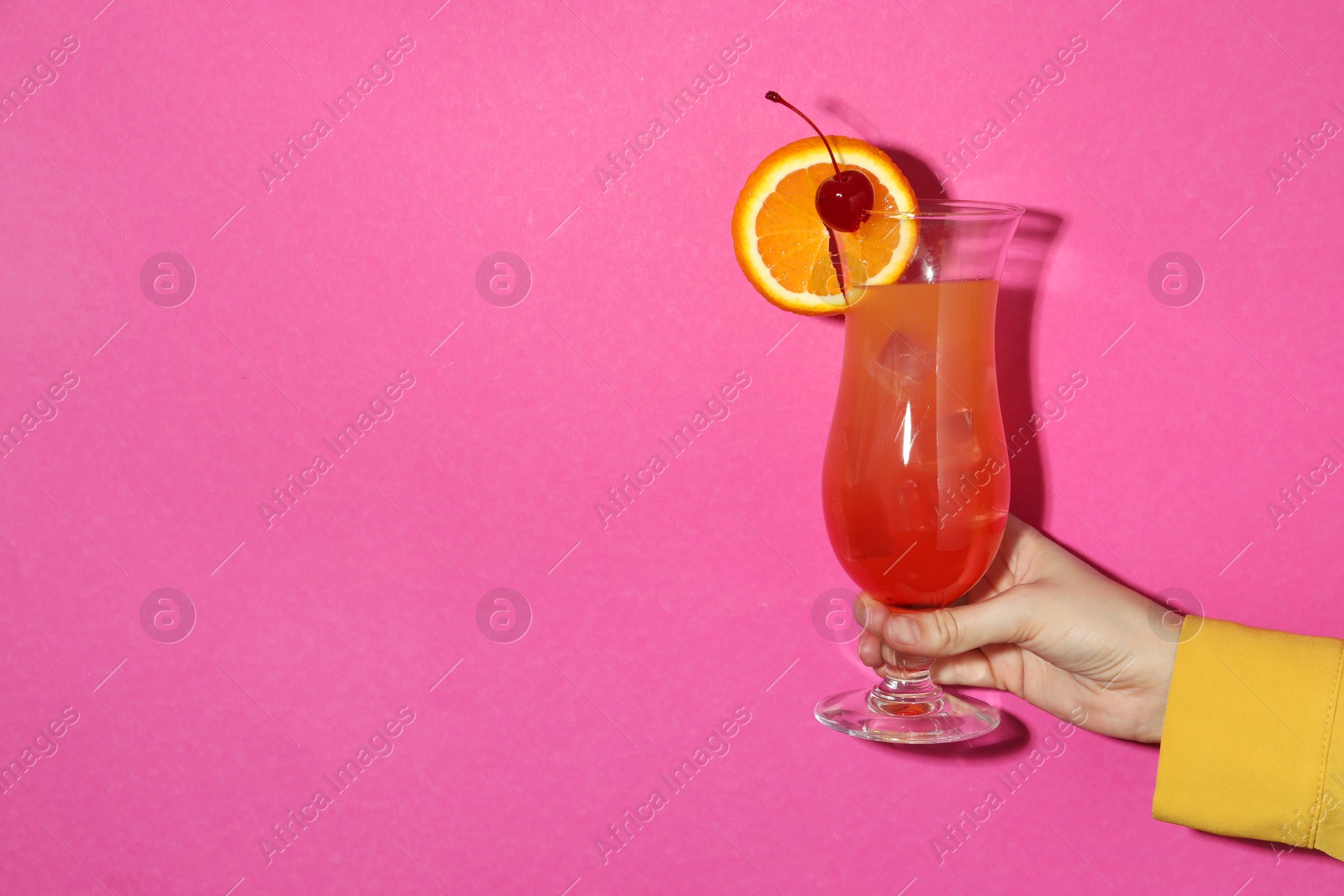 Photo of Woman with glass of refreshing cocktail on pink background, closeup. Space for text