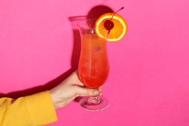 Photo of Woman with glass of refreshing cocktail on pink background, closeup