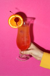 Photo of Woman with glass of refreshing cocktail on pink background, closeup