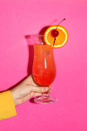 Photo of Woman with glass of refreshing cocktail on pink background, closeup