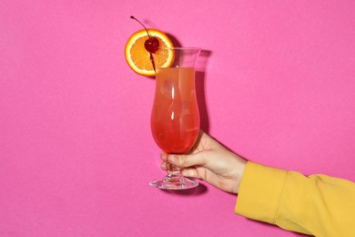 Photo of Woman with glass of refreshing cocktail on pink background, closeup