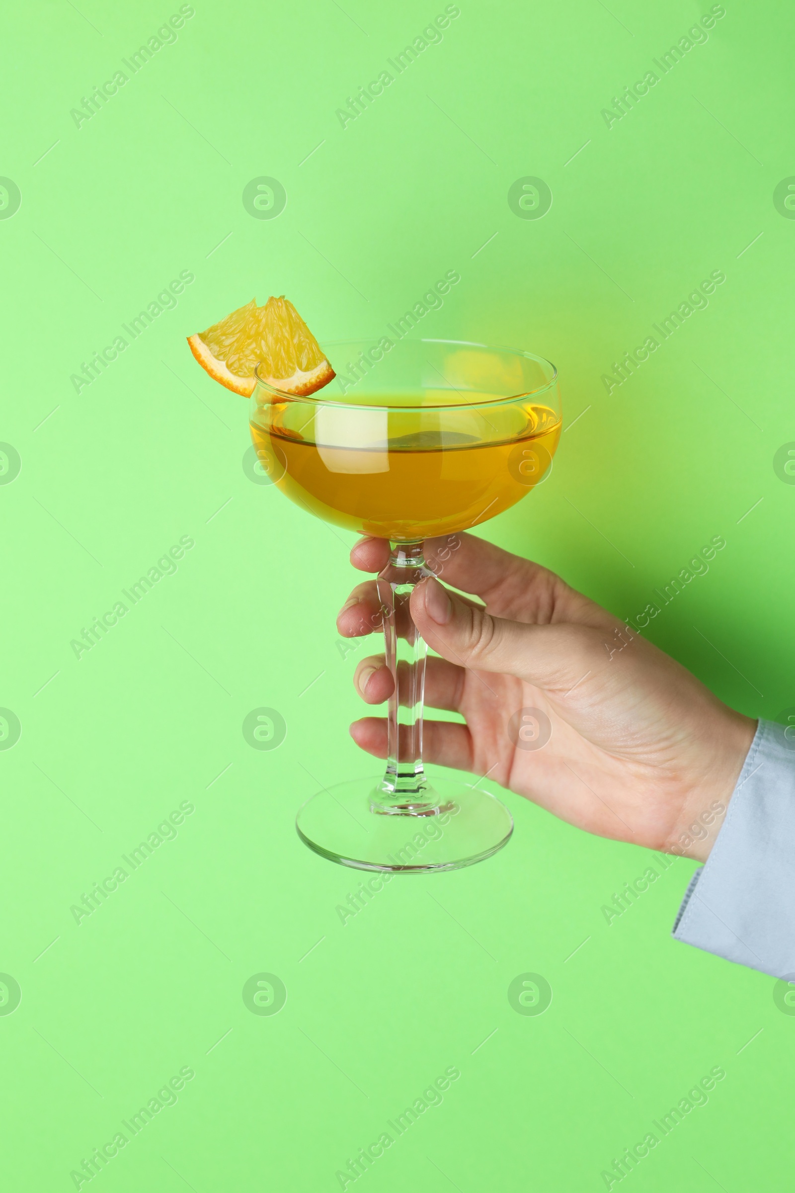 Photo of Woman with glass of refreshing cocktail on green background, closeup