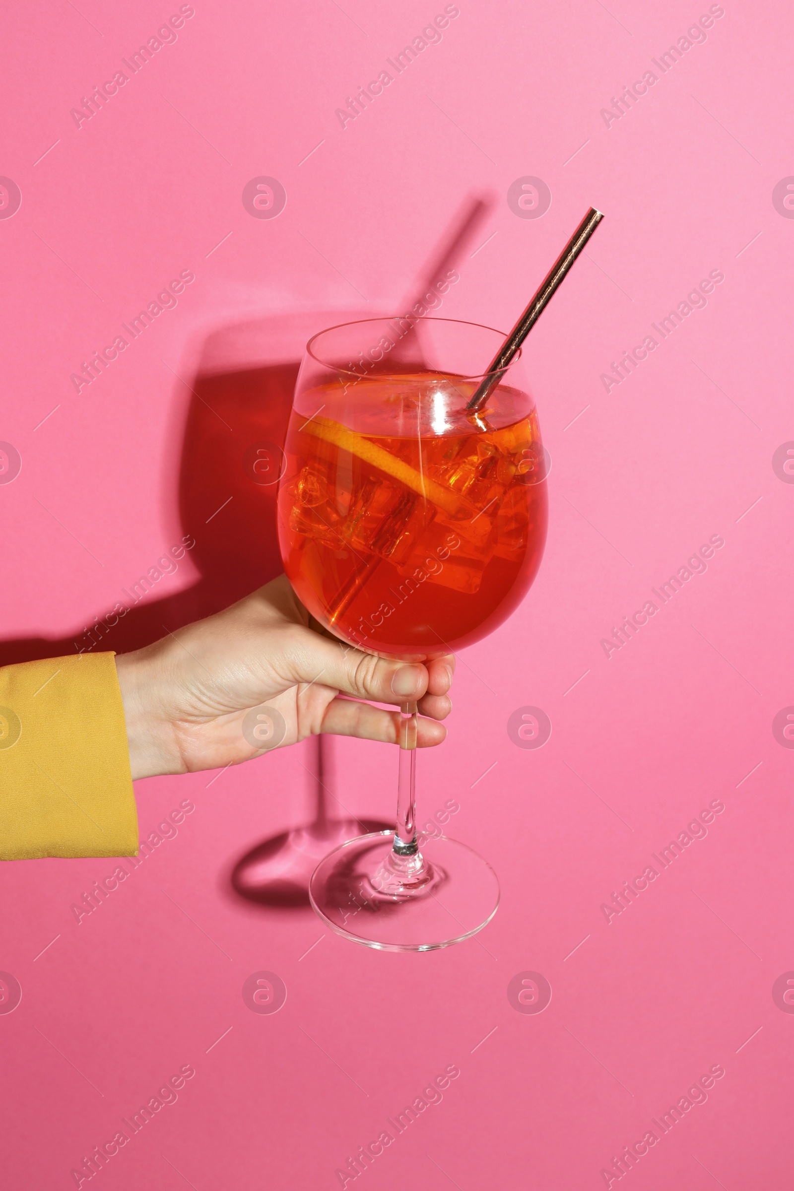 Photo of Woman with glass of refreshing cocktail on pink background, closeup