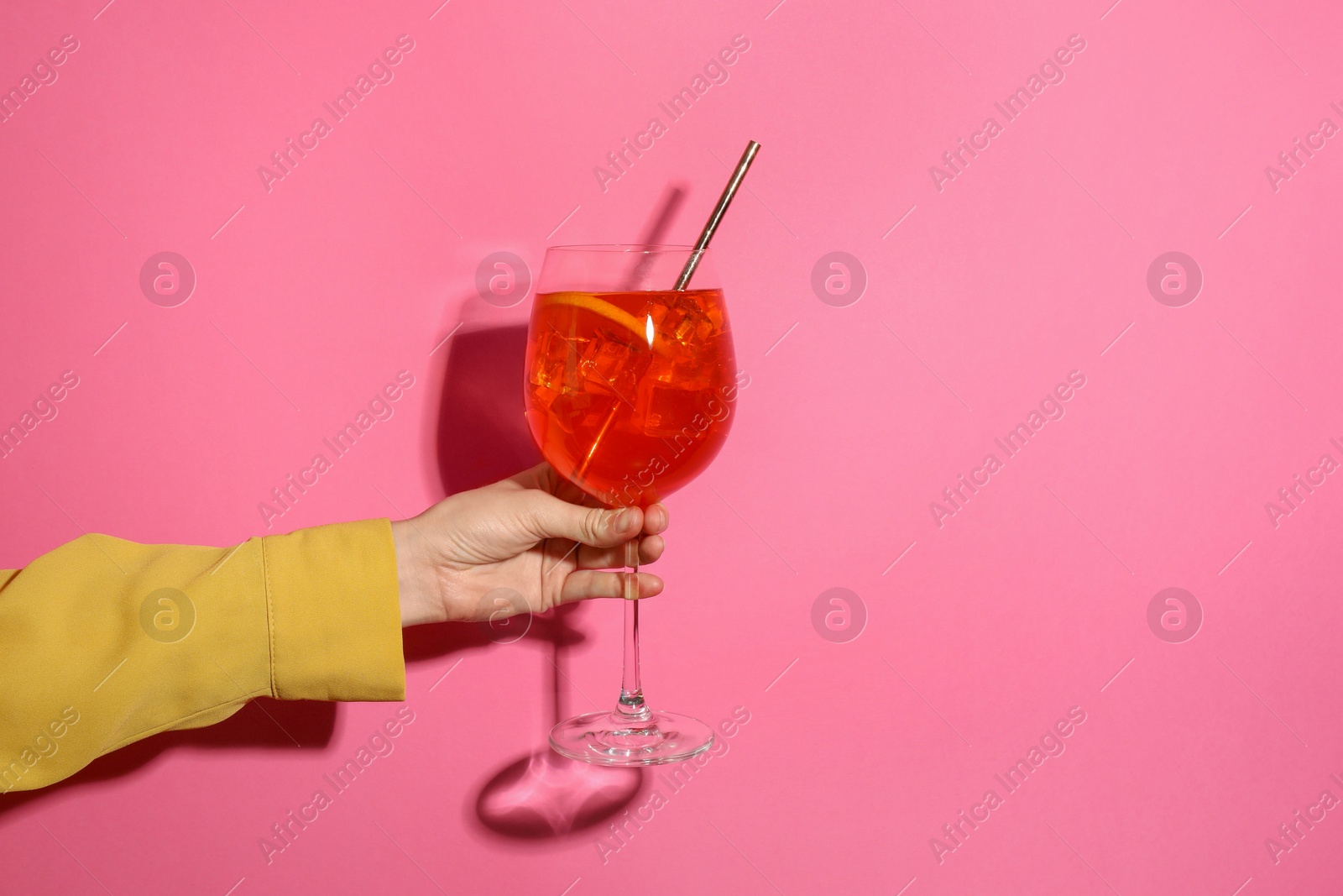 Photo of Woman with glass of refreshing cocktail on pink background, closeup. Space for text