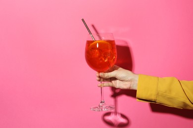 Photo of Woman with glass of refreshing cocktail on pink background, closeup. Space for text