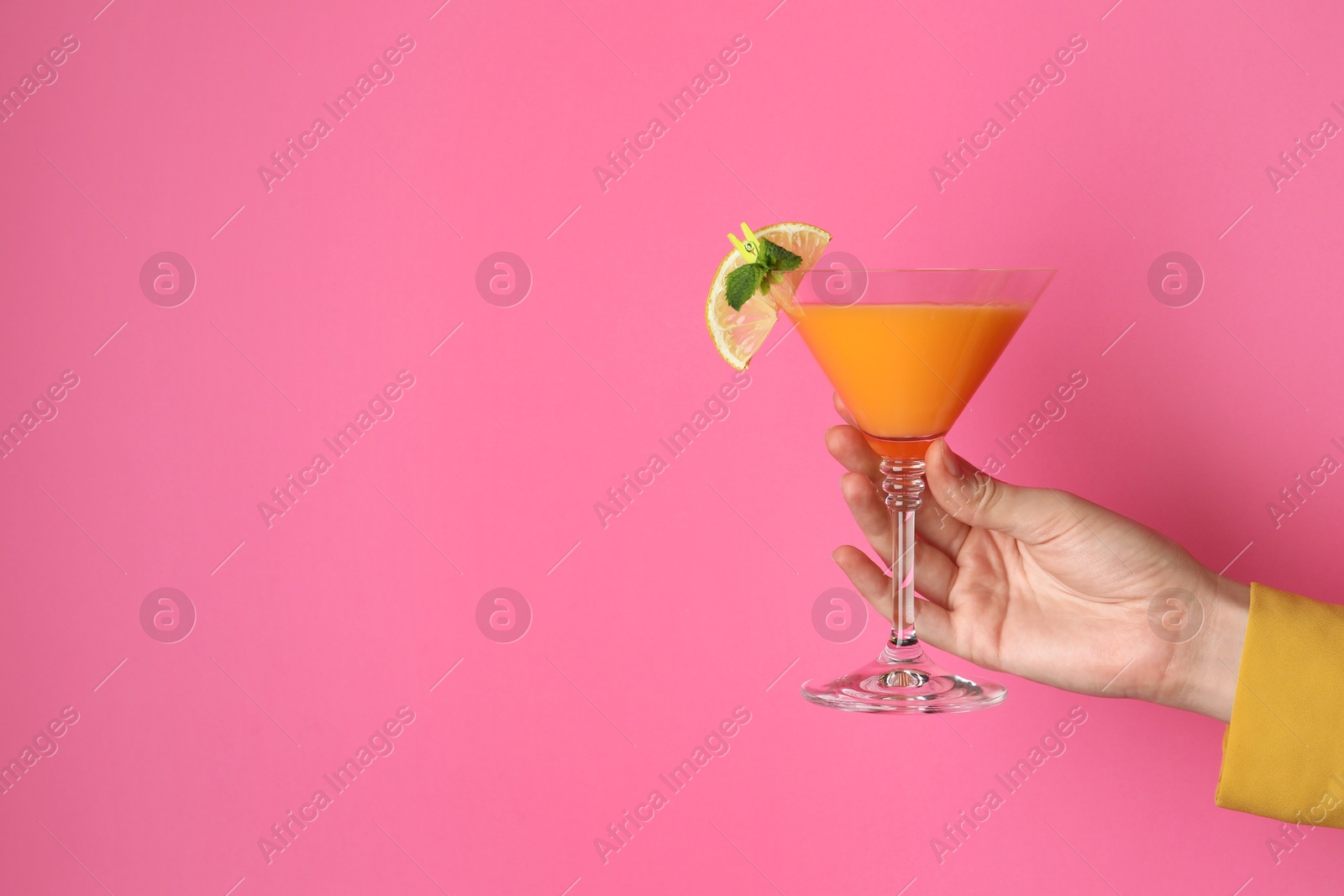 Photo of Woman with glass of refreshing cocktail on pink background, closeup. Space for text