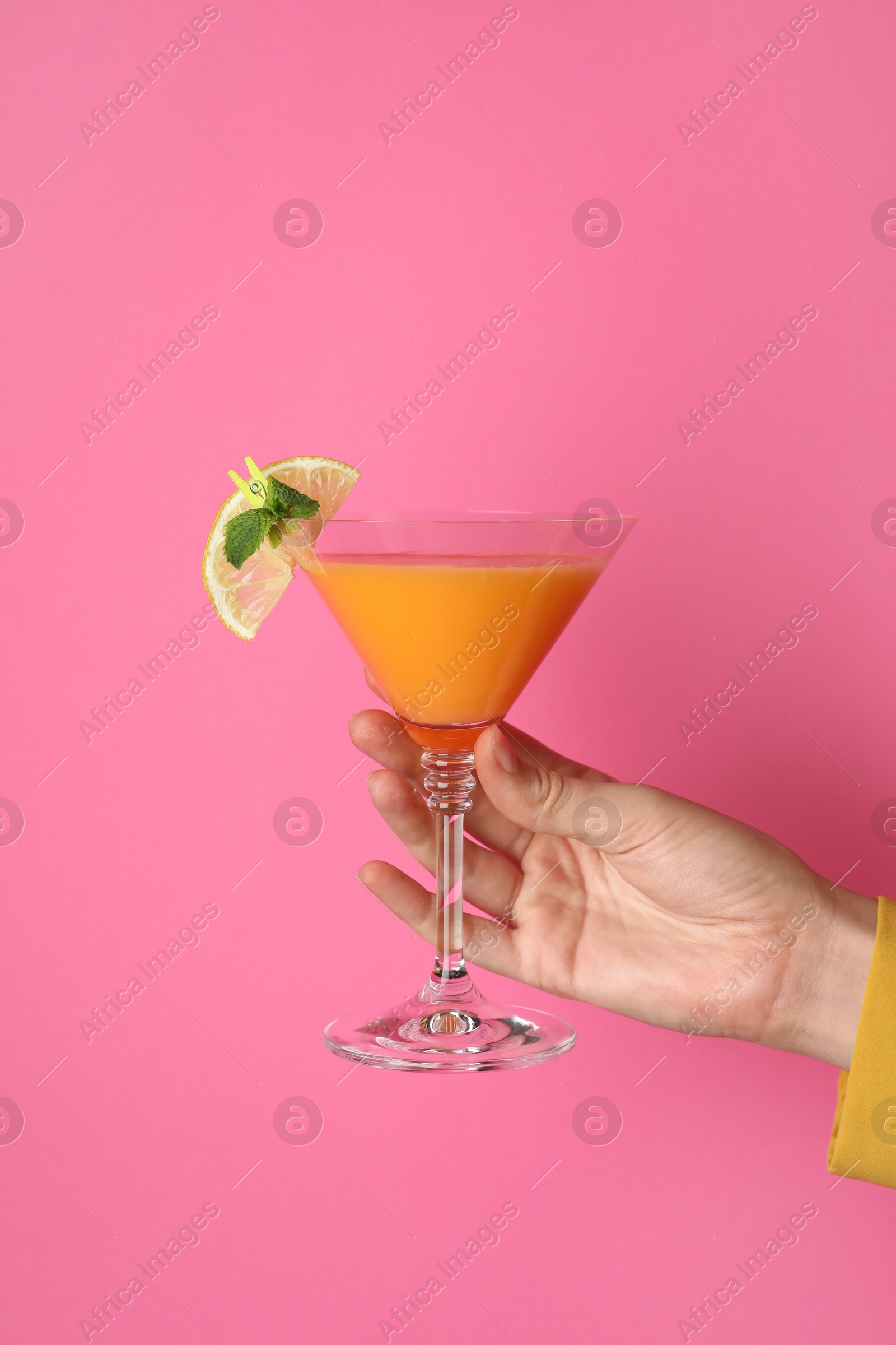 Photo of Woman with glass of refreshing cocktail on pink background, closeup