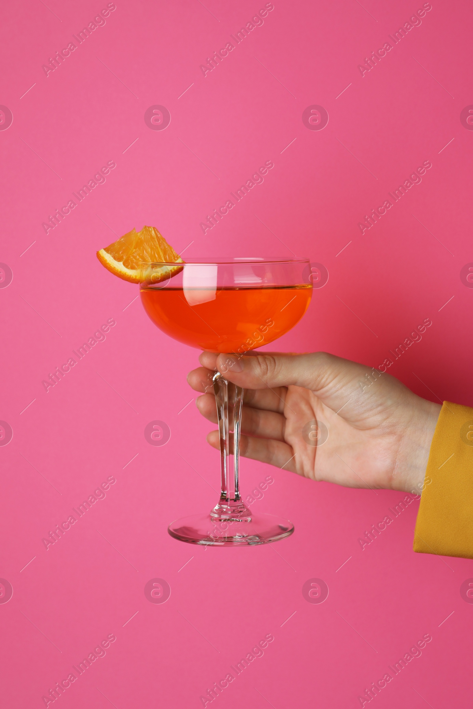 Photo of Woman with glass of refreshing cocktail on pink background, closeup