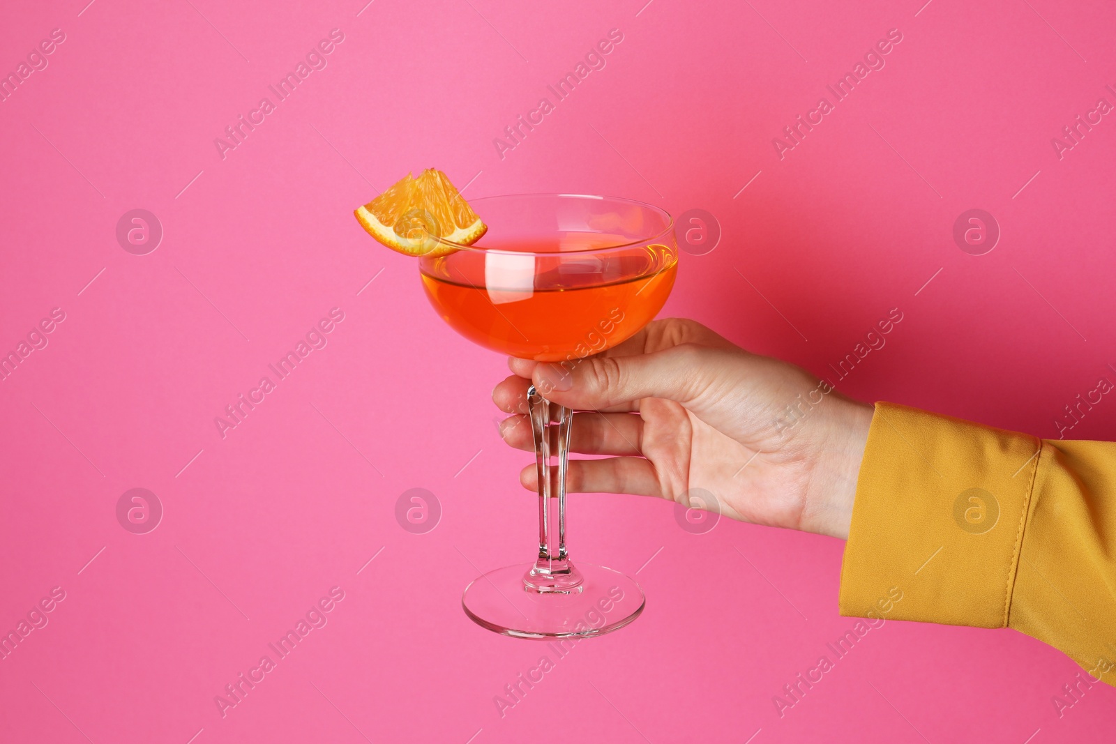 Photo of Woman with glass of refreshing cocktail on pink background, closeup